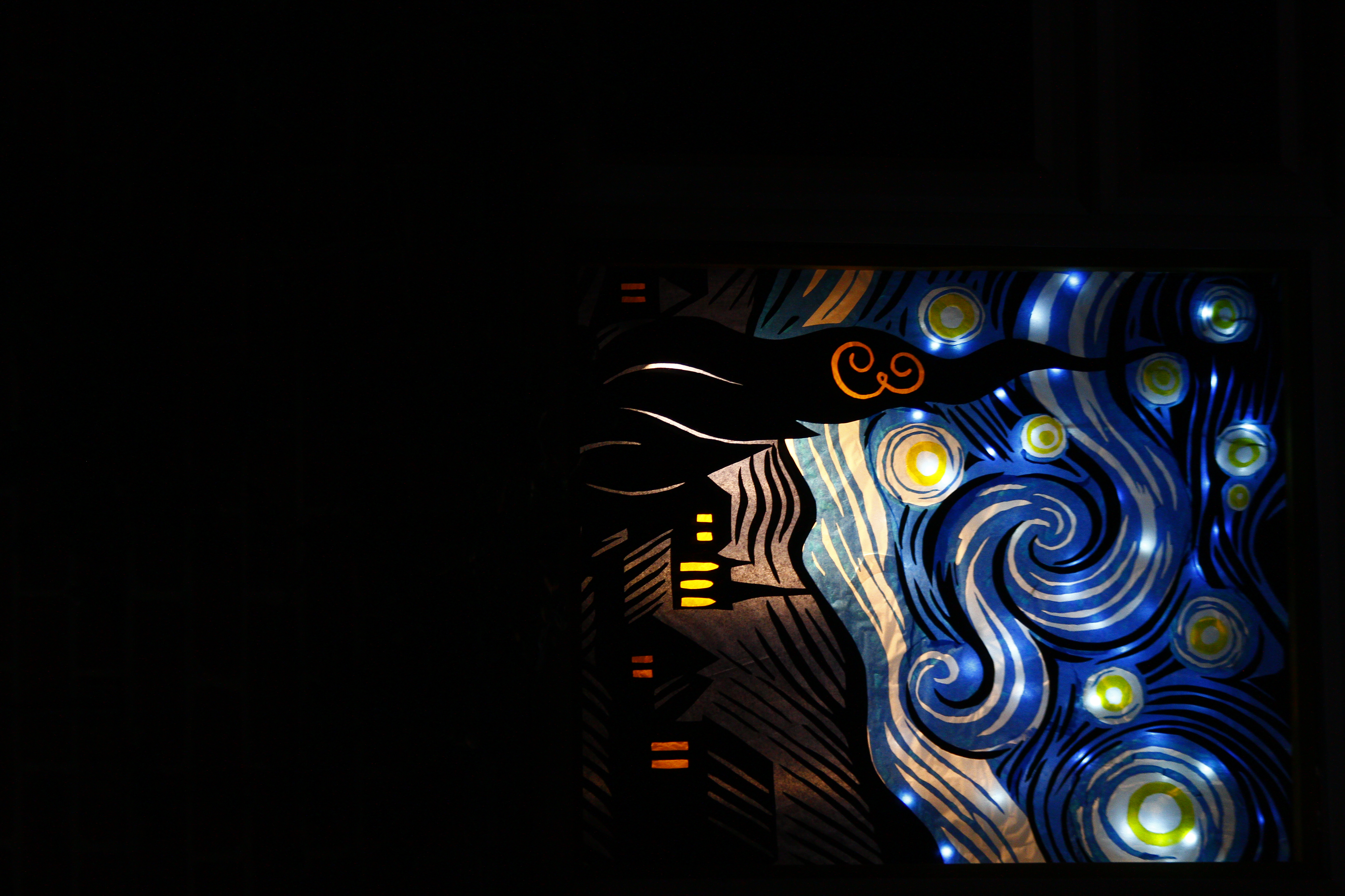 A tissue paper and card stylised recreation of the  starry night (painting) that is illuminated from the back. The number 3 is on the swirly spire thing on the mid-left.